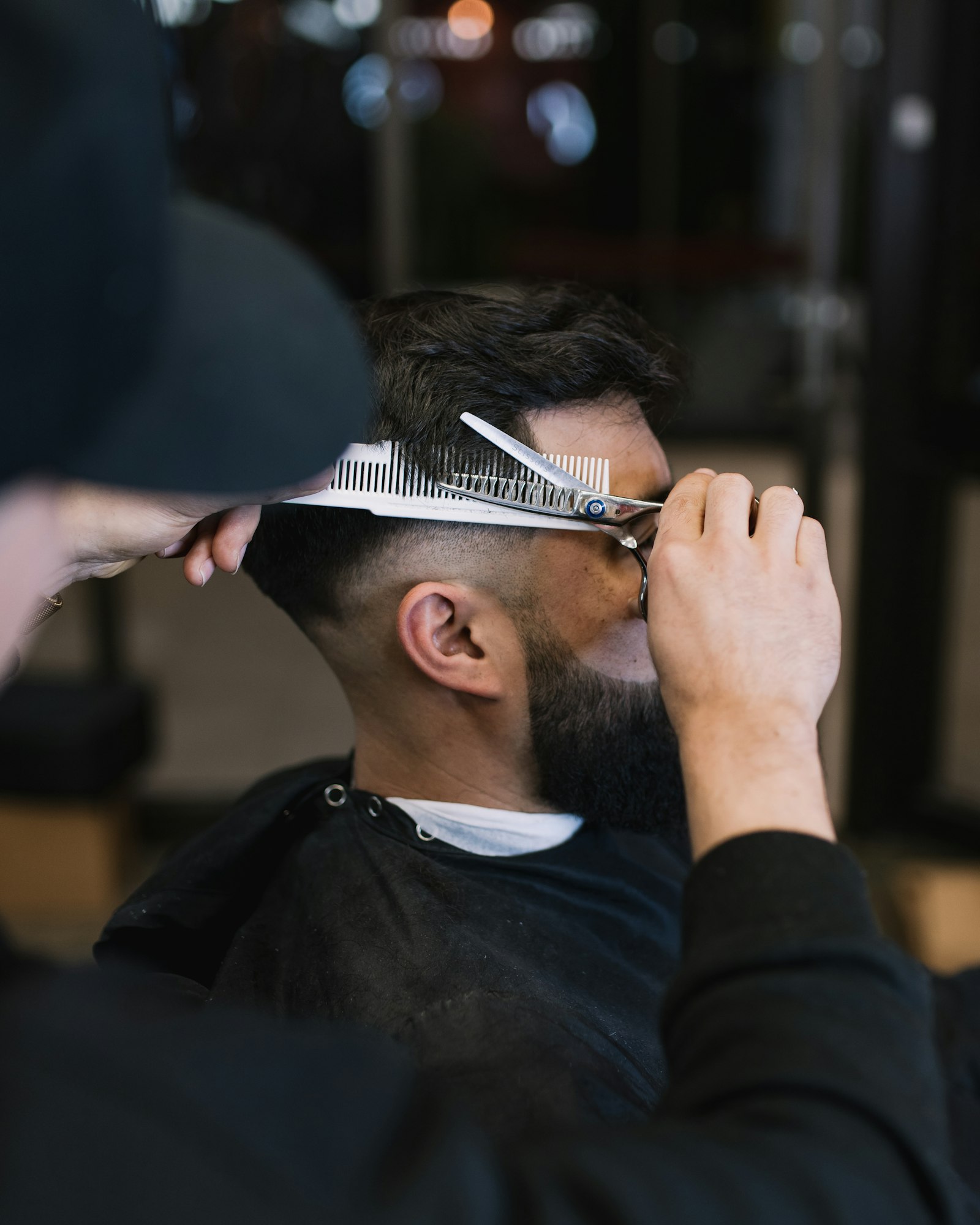 Barber trimming a client's beard
